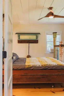 a bed in a room with a ceiling fan at Secluded Charming Farmhouse Lake Views Firepit in Narrowsburg