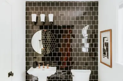 a black tiled bathroom with a sink and a mirror at Woods Edge Private 5 Acres Hot Tub Fire Pit in Barryville