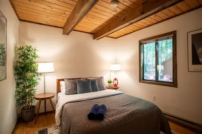 a bedroom with a bed with a pair of blue shoes on it at Hot Tub & Fire Pit: Cozy Pines Chalet in Poconos in Locust Lakes Village