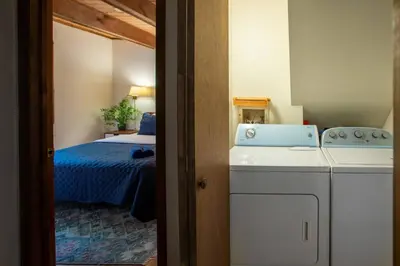 a small room with a bed and a washing machine at Hot Tub & Fire Pit: Cozy Pines Chalet in Poconos in Locust Lakes Village