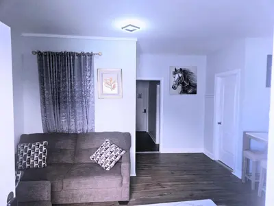 a living room with a couch and a horse on the wall at Home away from home 5 minutes away EWR Airport in Elizabeth