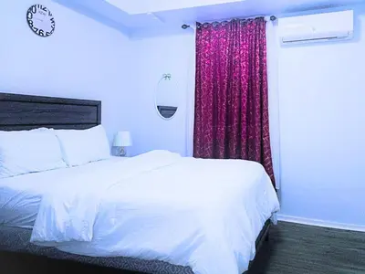 a bedroom with a white bed and a red curtain at Home away from home 5 minutes away EWR Airport in Elizabeth