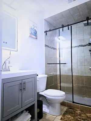 a bathroom with a toilet and a glass shower at Home away from home 5 minutes away EWR Airport in Elizabeth