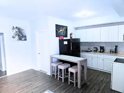a kitchen with a table and a black refrigerator at Home away from home 5 minutes away EWR Airport in Elizabeth
