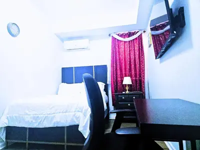 a bedroom with a bed and a table and a chair at Home away from home 5 minutes away EWR Airport in Elizabeth