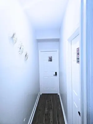 a hallway with a white door and a wooden floor at Home away from home 5 minutes away EWR Airport in Elizabeth