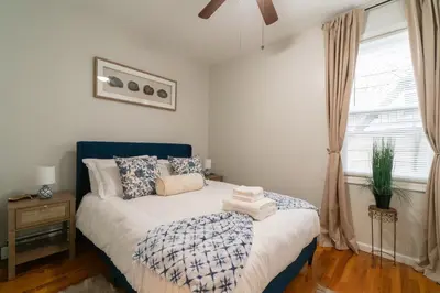 a bedroom with a blue and white bed with a window at The Boulevard Stay! 25 mins to NYC! Spacious 2BR! in Harrison