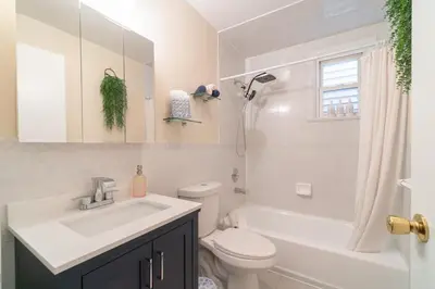 a white bathroom with a sink and a toilet at The Boulevard Stay! 25 mins to NYC! Spacious 2BR! in Harrison