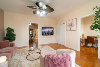 a living room with a couch and a ceiling fan at The Boulevard Stay! 25 mins to NYC! Spacious 2BR! in Harrison
