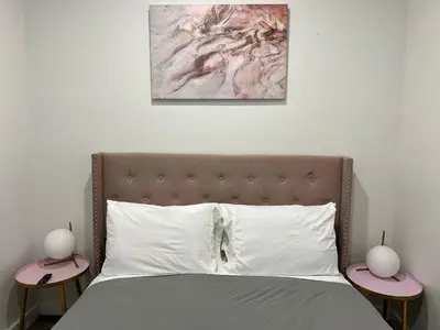 a bedroom with a bed with two lamps on tables at VibeHaus Midtown in New York