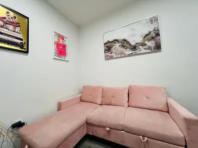 a couch in a living room with two pictures on the wall at VibeHaus Midtown in New York