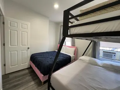 a bedroom with two bunk beds and a door at VibeHaus Midtown in New York