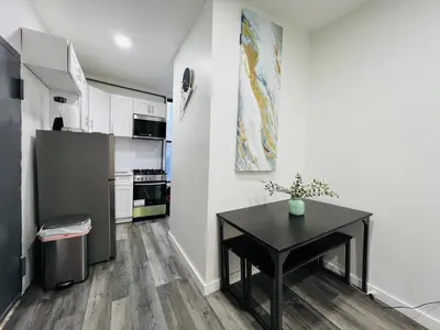 a kitchen with a black table and a refrigerator at VibeHaus Midtown in New York