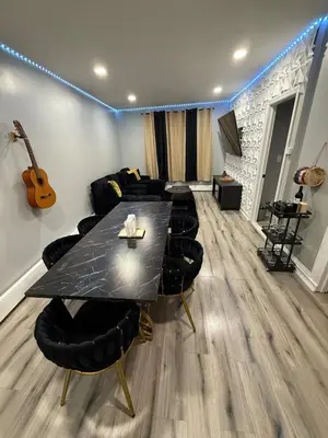 a room with a table and chairs and a guitar at EWRBNB - Rare Find! Huge 3BR Apartment with Open Layout minutes from Newark Airport & NYC - Apartment # 1 in Elizabeth