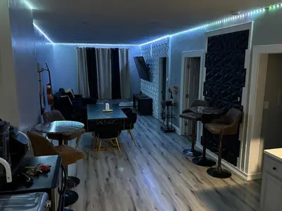 a living room with a table and chairs and blue lights at EWRBNB - Rare Find! Huge 3BR Apartment with Open Layout minutes from Newark Airport & NYC - Apartment # 1 in Elizabeth