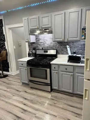 a kitchen with white cabinets and a stove top oven at EWRBNB - Rare Find! Huge 3BR Apartment with Open Layout minutes from Newark Airport & NYC - Apartment # 1 in Elizabeth