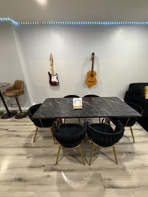 a table with chairs in a room with guitars on the wall at EWRBNB - Rare Find! Huge 3BR Apartment with Open Layout minutes from Newark Airport & NYC - Apartment # 1 in Elizabeth