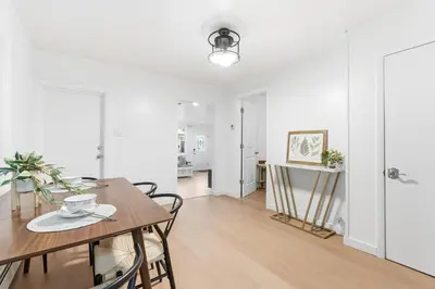 a white living room with a table and chairs at Hamilton-15 mins to EWR, 20 mins PATH to NYC in Harrison