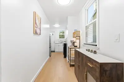 a kitchen with white walls and a wooden counter top at Hamilton-15 mins to EWR, 20 mins PATH to NYC in Harrison