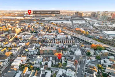 an aerial view of a city with a red arrow at Hamilton-15 mins to EWR, 20 mins PATH to NYC in Harrison