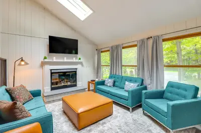 a living room with blue chairs and a fireplace at 1 Mi to Lake, Golf and Ski Access The Hideout Home! in Arlington