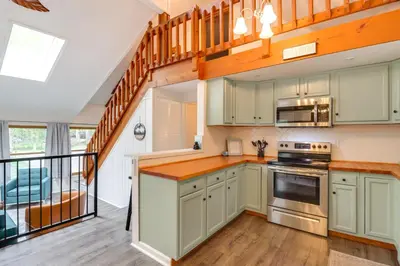 a kitchen with green cabinets and a staircase at 1 Mi to Lake, Golf and Ski Access The Hideout Home! in Arlington