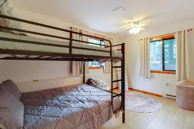 a bedroom with two bunk beds and a ceiling fan at 1 Mi to Lake, Golf and Ski Access The Hideout Home! in Arlington