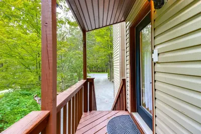 a porch of a house with a view of the woods at 1 Mi to Lake, Golf and Ski Access The Hideout Home! in Arlington