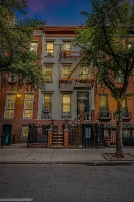 a large brick building with windows and a tree at Time Square Apartment in New York