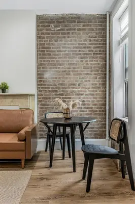 a dining room with a table and a brick wall at Time Square Apartment in New York