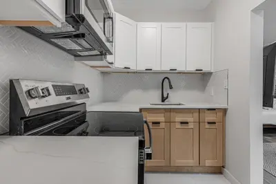 a kitchen with white cabinets and a sink at Time Square Apartment in New York
