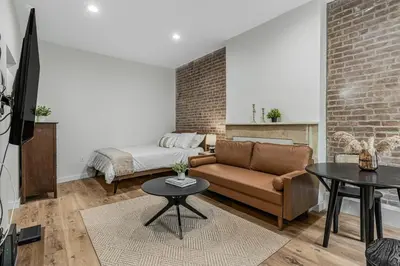 a living room with a couch and a bed at Time Square Apartment in New York