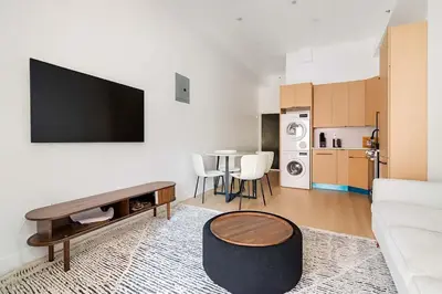 a living room with a couch and a tv on a wall at 19-4I Stylish 1BR in the Heart of the East Village in New York
