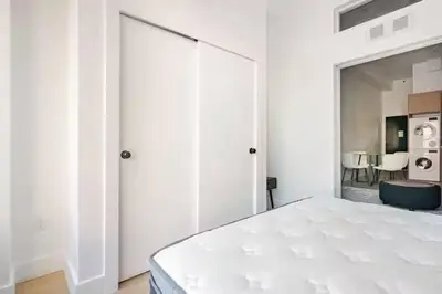 a white bedroom with a large sliding glass door at 19-4I Stylish 1BR in the Heart of the East Village in New York