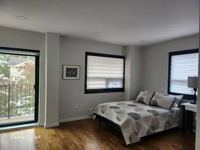 a bedroom with a bed and two windows at Modern & Tranquil Apartment in Bogota