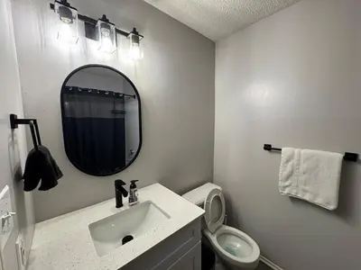 a white bathroom with a sink and a mirror at A private master room in modern complex shared apartment in Lawrenceville
