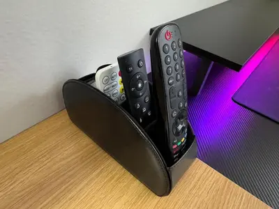 three remote controls sitting on top of a desk at A private master room in modern complex shared apartment in Lawrenceville