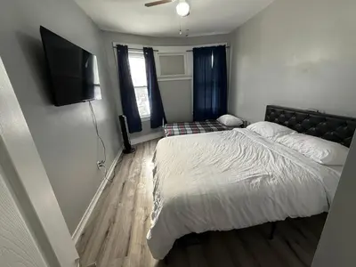 a bedroom with a bed and a flat screen tv at EWRBNB - Private Bedroom in Well sized Shared Apartment - 1 in Elizabeth