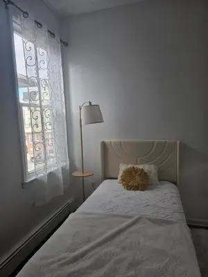 a white bedroom with a bed and a window at Cozy Getaway 2-Penn Station,NJPAC,Prudential Center in Kearny