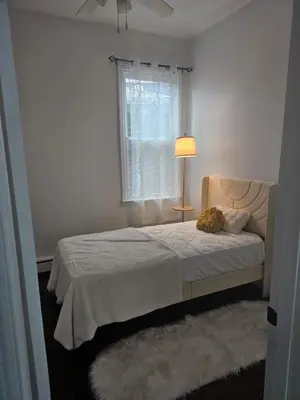 a bedroom with a bed with a lamp and a window at Cozy Getaway 2-Penn Station,NJPAC,Prudential Center in Kearny