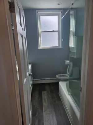 a bathroom with a shower and a toilet and a window at Cozy Getaway 2-Penn Station,NJPAC,Prudential Center in Kearny