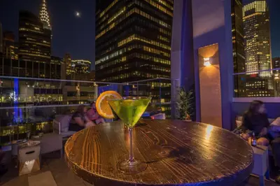a drink sitting on top of a table on a balcony at The Bernic Hotel New York City,Tapestry Collection by Hilton in New York