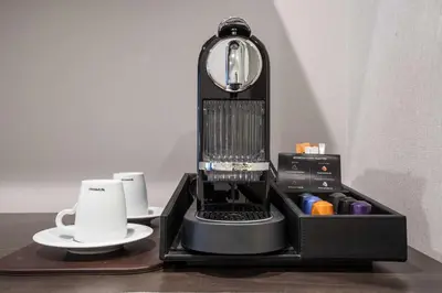 a black coffee machine sitting on a table at The Bernic Hotel New York City,Tapestry Collection by Hilton in New York