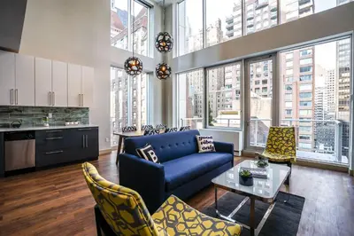 a living room with a blue couch and some chairs at The Bernic Hotel New York City,Tapestry Collection by Hilton in New York