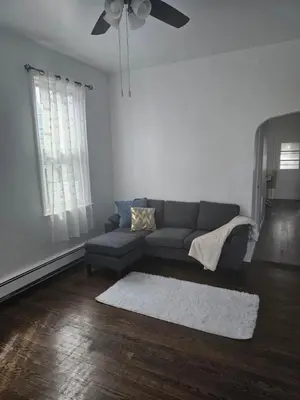 a living room with a couch and a ceiling fan at Cozy Getaway 3-Prudential Center, NJPAC, Penn Station in Kearny