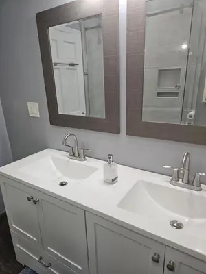 a bathroom with two sinks and a mirror at Cozy Getaway 3-Prudential Center, NJPAC, Penn Station in Kearny