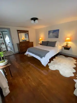a bedroom with a large bed and a wooden floor at The Big House at Elk Creek Escape in Hillsgrove