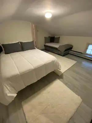 a bedroom with a large white bed and a window at The Big House at Elk Creek Escape in Hillsgrove