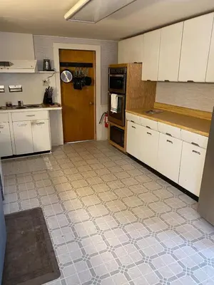 a kitchen with white cabinets and a tile floor at The Big House at Elk Creek Escape in Hillsgrove