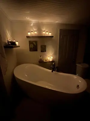 a large white tub in a bathroom with candles at The Big House at Elk Creek Escape in Hillsgrove